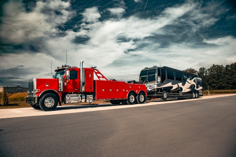 Century 5230 on a red peterbilt 589 chassis towing a motorcoach
